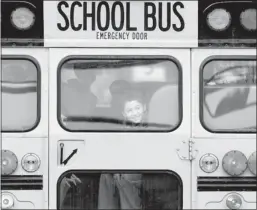  ?? Jason Decrow/the Associated Press ?? A boy smiles through his school bus window on the first day back in class for students in Newtown, Conn., since last Friday’s shootings. Reader says gun advocates must stop saying more guns will save more lives.