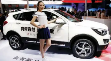  ??  ?? Posing by Haima S5 SUV at the Haima Automobile Group booth during the Auto China 2016 auto show in Beijing. — Reuters photos