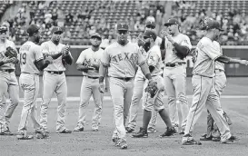  ?? [AP PHOTO] ?? Texas Rangers’ Adrian Beltre, center, is applauded by teammates as he walks off the field during the fifth inning Sunday against the Mariners in Seattle.