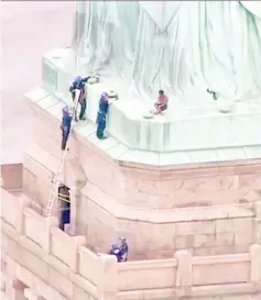  ??  ?? Police talking to Okoumou who climbed to the base of the Statue of Liberty in New York. — AFP photo