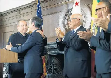  ?? CHRISTINA HOUSE Los Angeles Times ?? L.A. MAYOR Eric Garcetti congratula­tes LAPD Assistant Chief Michel Moore, left, at City Hall. Garcetti named Moore, known for his mastery of crime data, as successor to Chief Charlie Beck, who is retiring.