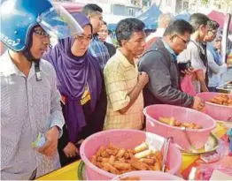  ??  ?? Orang ramai beratur untuk membeli popia basah dan popia goreng.