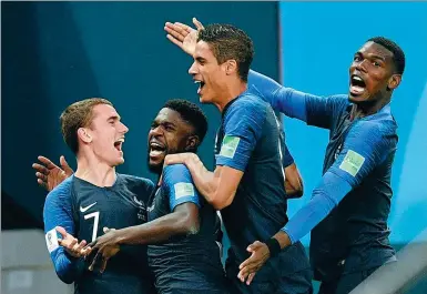  ?? MARTIN MEISSNER / AP ?? France’s Samuel Umtiti (second from left) is mobbed by teammates (from left) Antoine Griezmann, Raphael Varane and Paul Pogba after scoring the only goal of Tuesday’s World Cup semifinal victory over Belgium in St. Petersburg Stadium.