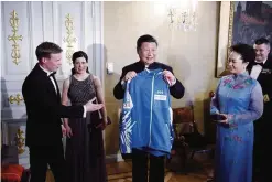  ?? —AP ?? HELSINKI: President of the People’s Republic of China Xi Jinping and wife Peng Liyuan (right) receives Finland’s national team training suits from Finnish nordic skiers Matti Heikkinen (left) and Krista P’rm’koski (2nd left) before an official state dinner yesterday in Helsinki, Finland.