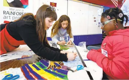  ?? K.C. ALFRED U-T PHOTOS ?? Vanessa Machin of the Rainforest Art Project works on a mosaic mural with fourth-graders Claudia Silva and Valentin Camargo.