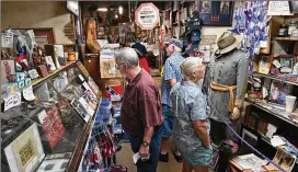  ?? PHOTOS BY HYOSUB SHIN/HYOSUB.SHIN@AJC.COM ?? Customers shop Thursday at Wildman’s Civil War Surplus, which first opened in downtown Kennesaw in 1971. When the owner, Dent Myers, died in January, Marjorie Lyon vowed to keep the shop open.