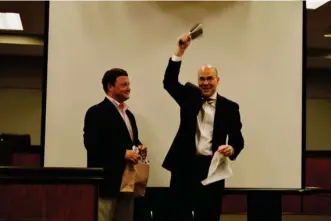  ?? (Photo by Sarah Raines, SDN) ?? At a farewell reception for Starkville's outgoing mayor, Mayor Parker Wiseman (right) rings a custom engraved cowbell presented to him by Interim CEO of the Greater Starkville Developmen­t Partnershi­p Heath Barret.