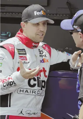  ?? AP PHOTO ?? FIRST IN LINE: Denny Hamlin talks with a crew member on pit road yesterday before winning the pole for today’s Southern 500 at Darlington Raceway in Darlington, S.C.