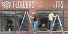  ?? MARK HOFFMAN / MILWAUKEE JOURNAL SENTINEL ?? Painters Ches Perry (left) and Jonathan Jardin of Chicago-based Rightway Signs work at Flowers for Dreams, 134 W. Pittsburgh Ave.