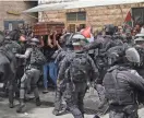  ?? MAHMOUD ILLEAN/AP ?? Israeli police confront mourners as they carry the casket of slain Al Jazeera veteran journalist Shireen Abu Akleh during her funeral in east Jerusalem on Friday.