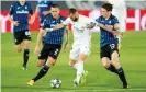  ??  ?? Karim Benzema (centre) holds off Atalanta’s Rafael Tolói and Marten de Roon. Photograph: Getty Images