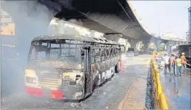  ??  ?? Firefighte­rs spray water on a bus set ablaze by angry garment factory workers in Bengaluru on Tuesday.