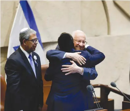 ?? (Yonatan Sindel/Flash90) ?? PRESIDENT ISAAC Herzog hugs outgoing president Reuven Rivlin after he was sworn in at the Knesset yesterday.