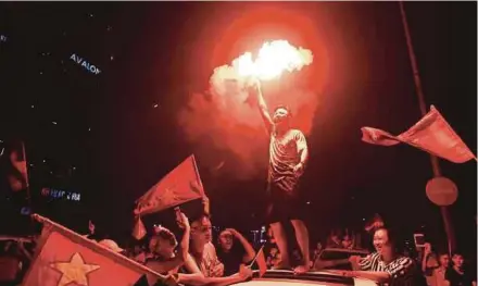  ?? AFP PIC ?? Vietnamese soccer fans celebrate their national team's victory over Syria in the Asian Games at a stadium in Hanoi on Monday.