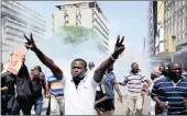  ?? PICTURE: REUTERS ?? Supporters of the Kenyan National Super Alliance opposition coalition, react after riot police officers fired tear gas canisters to disperse them during a demonstrat­ion in Mombasa, Kenya yesterday.