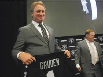  ?? Lea Suzuki / The Chronicle ?? Jon Gruden marks his return as head coach with a Raiders jersey at an introducto­ry news conference with owner Mark Davis, who said he had sought for six years to bring Gruden back.