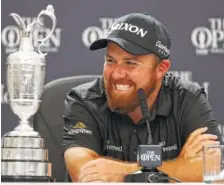  ?? AP PHOTO/PETER MORRISON ?? Ireland’s Shane Lowry smiles as he sits next to the Claret jug at a news conference after he won the British Open on Sunday.