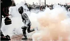  ??  ?? CLASHES between protesters and police near Tahrir Square in Cairo, Egypt, in January 2013. The street is shrouded in tear gas.