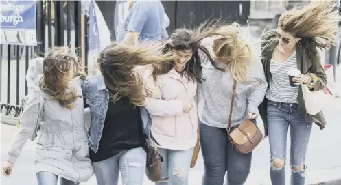  ??  ?? Women battle against strong winds in Edinburgh yesterday, as Storm Hector, far left, made its way across the country. Police officers in the West End of Glasgow deal with a fallen tree