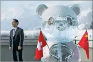  ?? LAURENT GILLIERON / REUTERS ?? A panda ice sculpture is pictured with the Swiss and Chinese flags during the launch of the Swiss-Sino Year of Tourism in Davos on Tuesday.