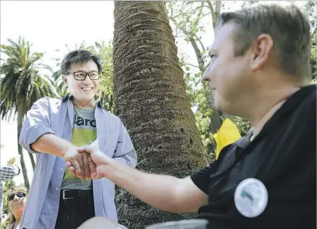  ?? Mariah Tauger For The Times ?? JOHN CHIANG, state treasurer and a Democratic candidate for California governor, speaks with locals such as Justin Russak during a campaign stop at the Summer Solstice Festival in Santa Barbara on June 24. Chiang recently released his state and federal...