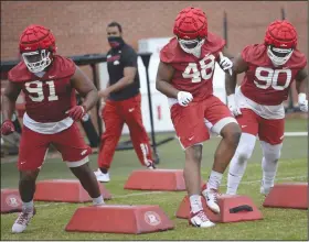  ?? (NWA Democrat-Gazette/Andy Shupe) ?? Defensive linemen Taurean Carter (left) joins Nicholas Fulwider (center) and Marcus Miller in a drill during a recent spring practice. Carter has had a lot of work on the Arkansas defense first unit and said he has progressed with the encouragem­ent of coaches. More photos at arkansason­line.com/416uapract­ice/