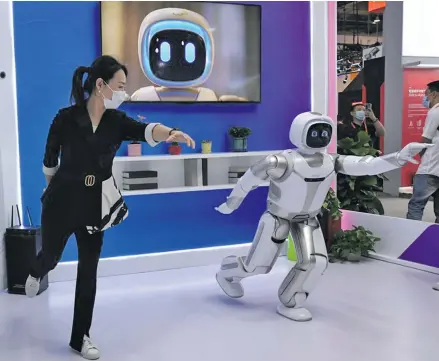 ?? Photo: Xinhua ?? A woman interacts with a service robot (R) during the 2020 China Internatio­nal Fair for Trade in Services (CIFTIS) in Beijing, capital of China, September 6, 2020.