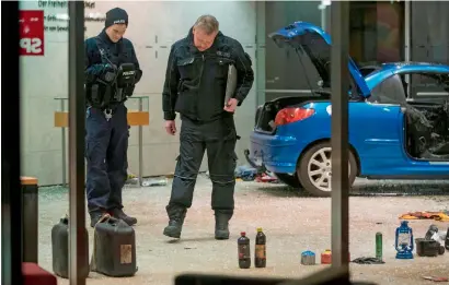  ?? AFP ?? Police officers inspect the damage at the lobby of the German Social Democratic Party headquarte­rs in Berlin on Monday. —