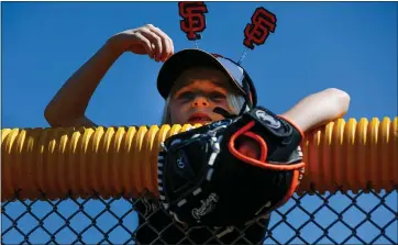  ?? RANDY VAZQUEZ — STAFF ARCHIVES ?? Reagan Herwaldt, 7, watches San Francisco Giants players warm up before the team’s Cactus League game against the Arizona Diamondbac­ks at Scottsdale Stadium.