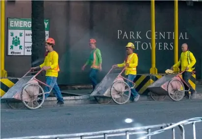  ?? PHOTOGRAPH BY KING RODRIGUEZ FOR THE DAILY TRIBUNE ?? CONSTRUCTI­ON workers pushing cement carts is a normal sight at a rising condominiu­m in Makati City.