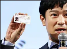  ?? KYODO NEWS VIA AP FILE ?? Japanese actor Masato Sakai shows a sample of My Number card during a promotiona­l event in Tokyo on March 8, 2021. The Japanese public has been slow to warm up to the cards, which have photos and microchips. Public health insurance cards now in use, which lack photos, will be discontinu­ed in late 2024.