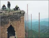  ?? LUO XIAOGUANG / XINHUA ?? Workers analyze a section of the Great Wall at Donggou village in Beijing’s Miyun district in August.