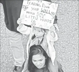  ??  ?? Marcha realizada ayer en el centro de Los Ángeles contra la política migratoria del presidente Donald Trump, que incluye la construcci­ón de un muro en la frontera con México. En el cartel se lee: “Derribando tu muro con mis pequeñas manos” ■ Foto Ap