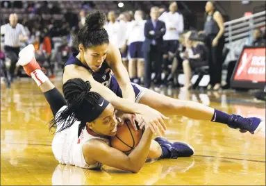  ?? Michael Wyke / Associated Press ?? Houston’s Angela Harris, left, fights for a loose ball with UConn’s Crystal Dangerfiel­d on Saturday.