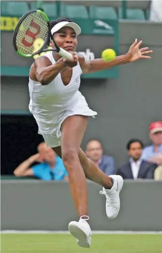  ?? THE ASSOCIATED PRESS ?? Venus Williams returns a shot to Belgium’s Elise Mertens during their opening day match at the Wimbledon Tennis Championsh­ips on Monday.