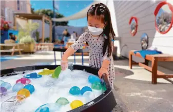  ?? PEEKADOODL­E ?? A child explores a water table at Peekadoodl­e, a preschool in the Inner Richmond. The indoor-outdoor learning space includes a 2,500-square-foot play yard that has sand and water features.