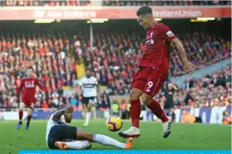  ??  ?? LIVERPOOL: Fulham’s Belgian defender Denis Odoi (L) slides in to tackle Liverpool’s Brazilian midfielder Roberto Firmino (R) during the English Premier League football match between Liverpool and Fulham at Anfield in Liverpool, north west England yesterday. — AFP