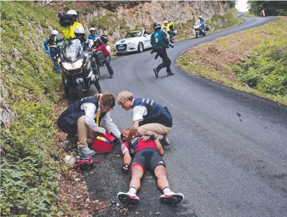  ??  ?? Australian Richie Porte is treated after crashing heavily on the descent of the Mont du Chat pass.