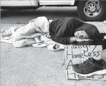 ?? Peggy Peattie San Diego Union-Tribune ?? A MAN SLEEPS on the street in San Diego, where a hepatitis A outbreak struck the homeless community. San Diego Mayor Kevin Faulconer asked the state to remove red tape delaying housing constructi­on.