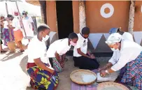  ?? — Picture: John Manzongo ?? First Lady Auxillia Mnangagwa teaches girls how to grind millet the traditiona­l way using grinding stone during nhanga/gota/ixiba session in Bulawayo yesterday.