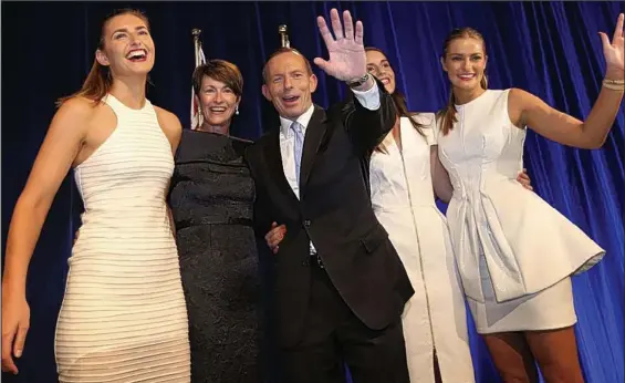  ??  ?? Victory: Tony Abbott, wife Margaret and – all in white outfits, from left – daughters Frances, Louise and Bridget celebrate his win in Sydney