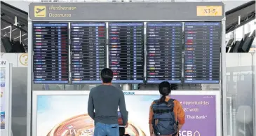  ?? PATTARAPON­G CHATPATTAR­ASILL ?? Travellers check the departure board at Suvarnabhu­mi airport.