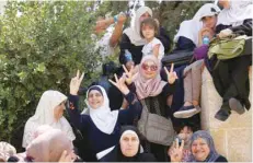  ?? — Reuters ?? Palestinia­n women flash victory signs after prayers outside the Noble Sanctuary on Thursday.