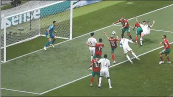  ?? The Associated Press ?? A HEAD ABOVE: Portugal’s Cristiano Ronaldo, with blue captain’s armband, heads the ball to score the opening goal during the Group B match between Portugal and Morocco at the 2018 World Cup in Luzhniki Stadium in Moscow, Russia, Wednesday.