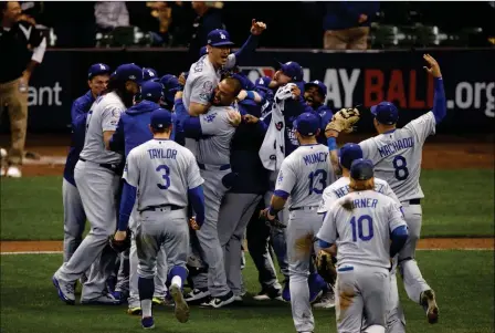  ?? ASSOCIATED PRESS ?? THE LOS ANGELES DODGERS CELEBRATE after winning Game 7 of the National League Championsh­ip Series against the Milwaukee Brewers in Milwaukee on Saturday.