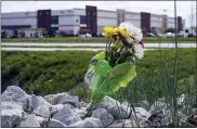  ?? MICHAEL CONROY — THE ASSOCIATED PRESS ?? A bouquet of flower sits in the rocks across the street from the FedEx facility in Indianapol­is where eight people were shot and killed.