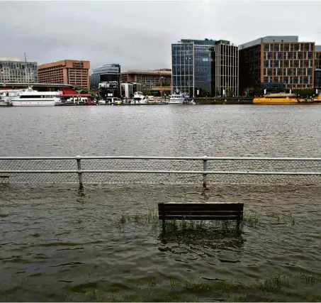  ??  ?? Banco de parque na capital Washington (EUA) fica submerso por inundação durante passagem do furacão Florence