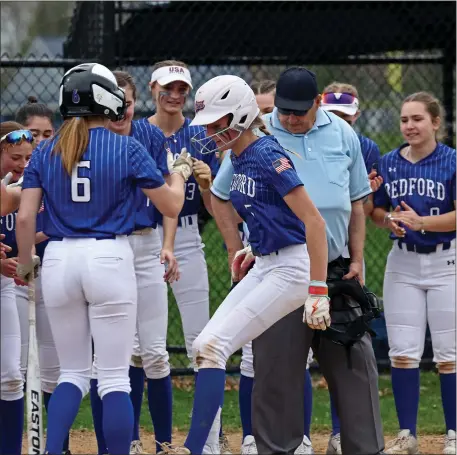  ?? STAFF PHOTO — STUART CAHILL/BOSTON HERALD ?? Bedford’s Alyx Rossi is welcomed home after her solo home run during a softball game against Triton. Host Bedford was a 2-0 winner.