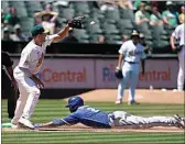  ?? JEFF CHIU / AP ?? Kansas City Royals’ Michael A. Taylor, bottom, slides into third base after hitting a triple next to Oakland Athletics third baseman Jonah Bride during the seventh inning of a baseball game in Oakland on Saturday.
