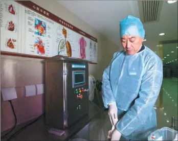  ?? PROVIDED TO CHINA DAILY ?? Xu Jun prepares for an embalming operation at the Baoxing Funeral Parlor in Shanghai.